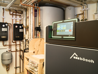 Moderne Kombi-Heizungsanlage von bösch im Keller eines Gebäudes, ausgestattet mit einem digitalen Steuerungssystem und mehreren verrohrten Heizkomponenten. | © Walter Bösch GmbH & Co KG